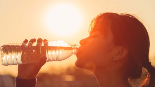 A person drinks from a water bottle