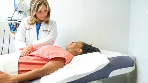 A physician examines a patient in a medical exam room