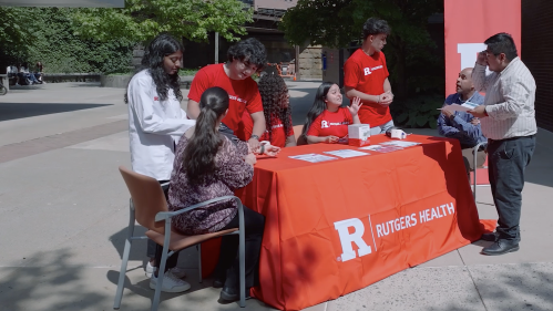 RHS Corps members sit at a table outside in New Brunswick 