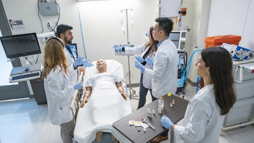 Pharmacy students take patient vitals in a simulation exam room 