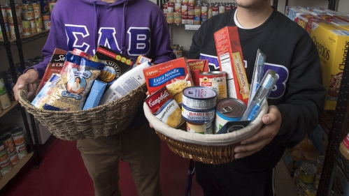 Students hold baskets of food in the Rutgers Health Food Pantry