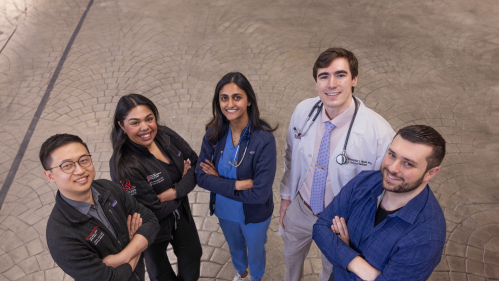 Five Rutgers Health residents smile and look up at the camera