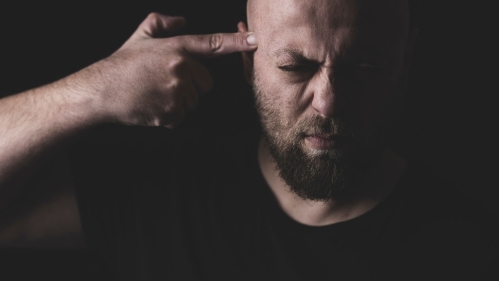man points gun finger to his head