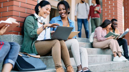 students outside class on steps with laptops
