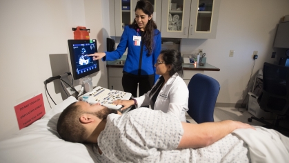 Clinicians conduct an ultrasound scan on a patient