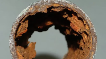 A cross-section of a corroded lead pipe