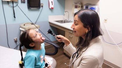 A doctor looks into a young patient's mouth