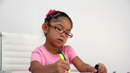 A young girl draws with a highlighter