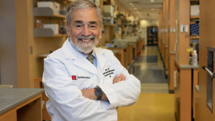Chancellor Brian Strom wearing a white coat, standing in a lab