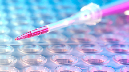 pipette is held sideways over miniature test tubes