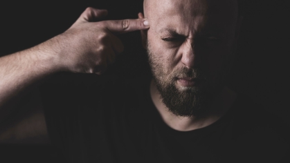 man points gun finger to his head