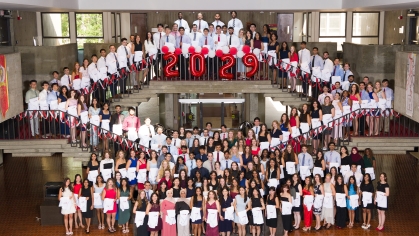 Medical school students holding their white coats 