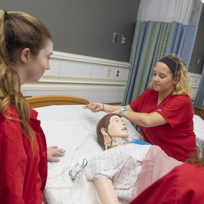 Nursing students practice on a simulation patient