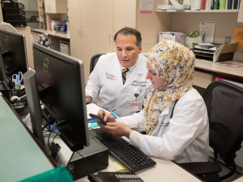 Professor of medicine and cardiology fellow go over notes