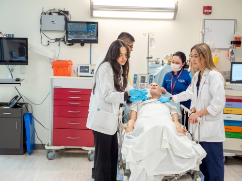 Pharmacy students practice on a mannequin in a skills lab