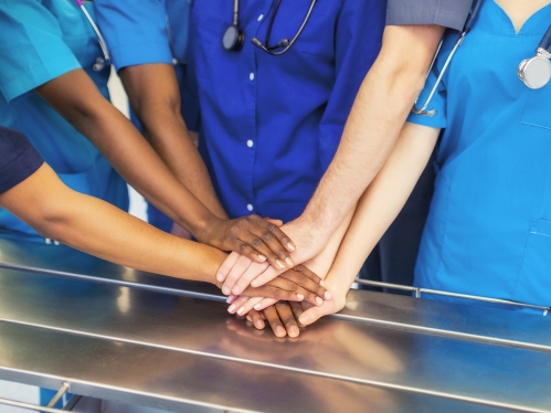 Medical school students stack their hands in teamwork