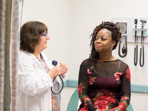 A physician examines a patient in a medical exam room