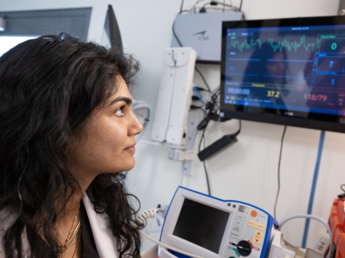 An RWJMS student looks at vital signs on a screen in the Pharmacy Simulation Lab