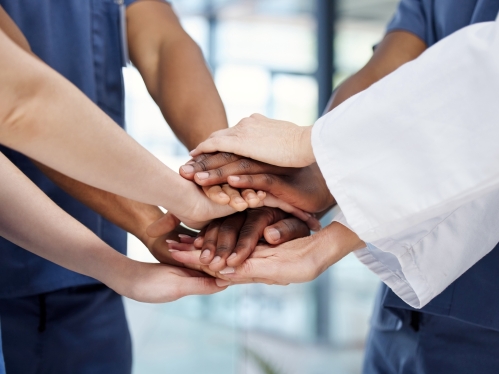 Medical students stack their hands in a show of teamwork