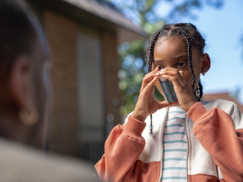 A child uses an inhaler for asthma