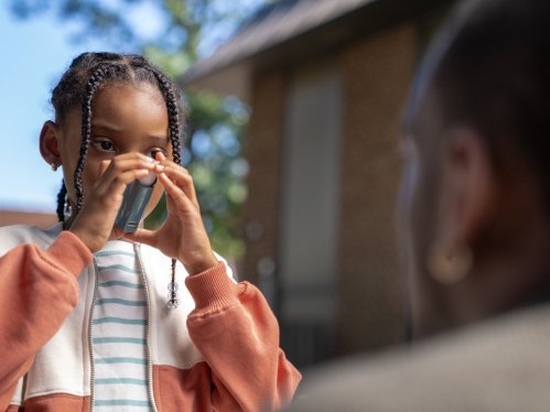 A child uses an inhaler during an asthma attack