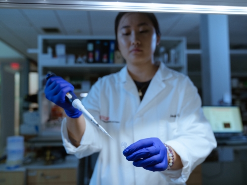 An asthma researcher works with equipment in a lab at Rutgers.