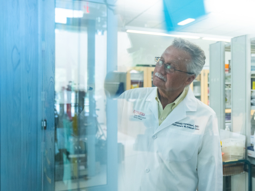 Asthma researcher Reynold Panettieri writes on a board in a lab.