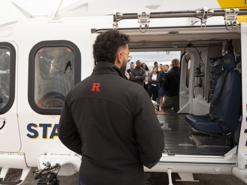 Emergency medicine residents look into an EMS helicopter on the hospital rooftop.
