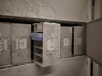 A bank of freezers labeled alphabetically.