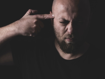 man points gun finger to his head