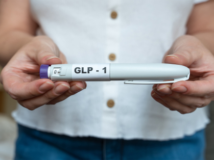 Women in white shirt holding GLP-1 medication 