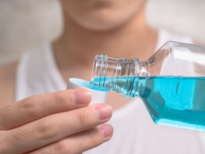 woman pours mouthwash