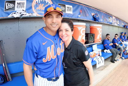 Theresa Corderi, who served as the chef for the New York Mets, hugs former Mets Manager Luis Rojas in the dugout