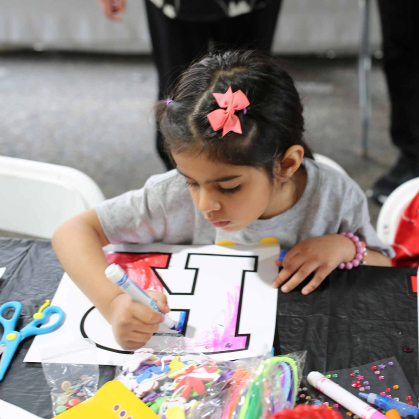 Hania Raja, 5, colors with a marker in the R Garden next to the College Avenue Student Center.