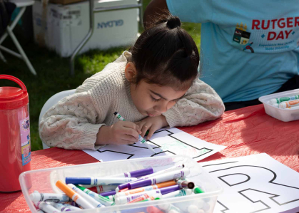 Luciana Medina colors a Rutgers “R” at the R Garden on Voorhees Mall during Rutgers Day 2024.