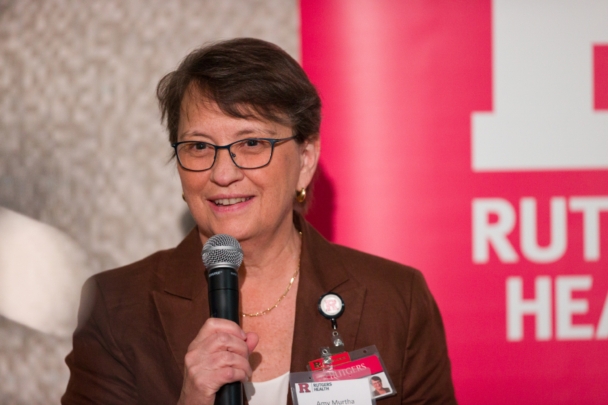 Dean Amy Murtha speaks into a microphone during the Integration Summit