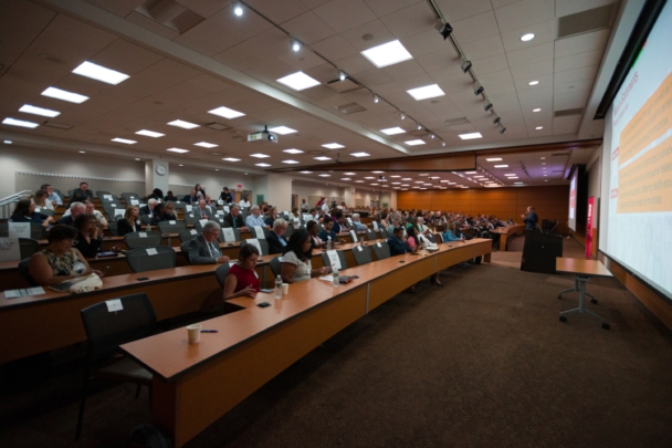 Participants listen to a presentation in a lecture hall during the Integration Summit 