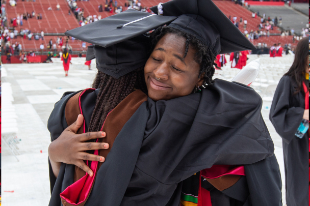 A graduating student hugging a loved one.