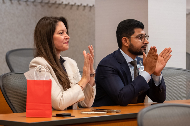 Two attendees clap as they listen to a speaker at the 2026 Integration Summit in Newark