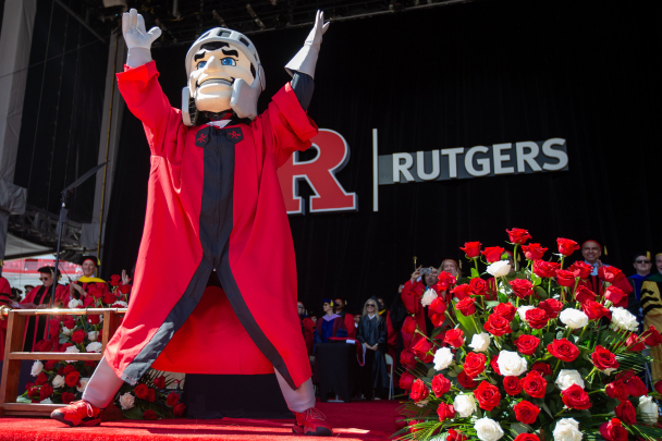 Sir Henry, the Scarlet Knight standing on stage at commencement wearing regalia