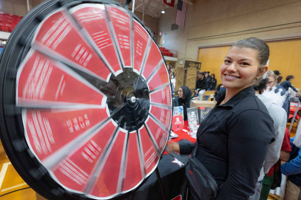 Christina Monti runs a spinning wheel question game inside the College Avenue Gymnasium during Rutgers Day.