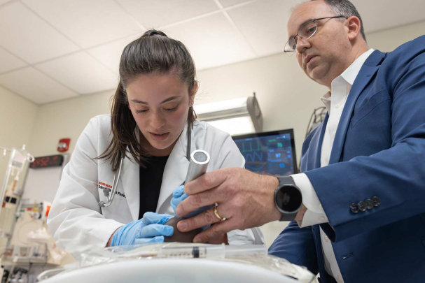 Under the guidance of Les Barta (right), Amanda Sallemi practices a direct laryngoscopy for endotracheal intubation (or, in other words, placing a breathing tube) on a manikin.