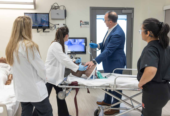 Amanda Sallemi (second from left) practices with a video laryngoscope to visualize anatomy within a manikin as Alex Bell (left), Les Barta and Aj Rose look at a computer screen.